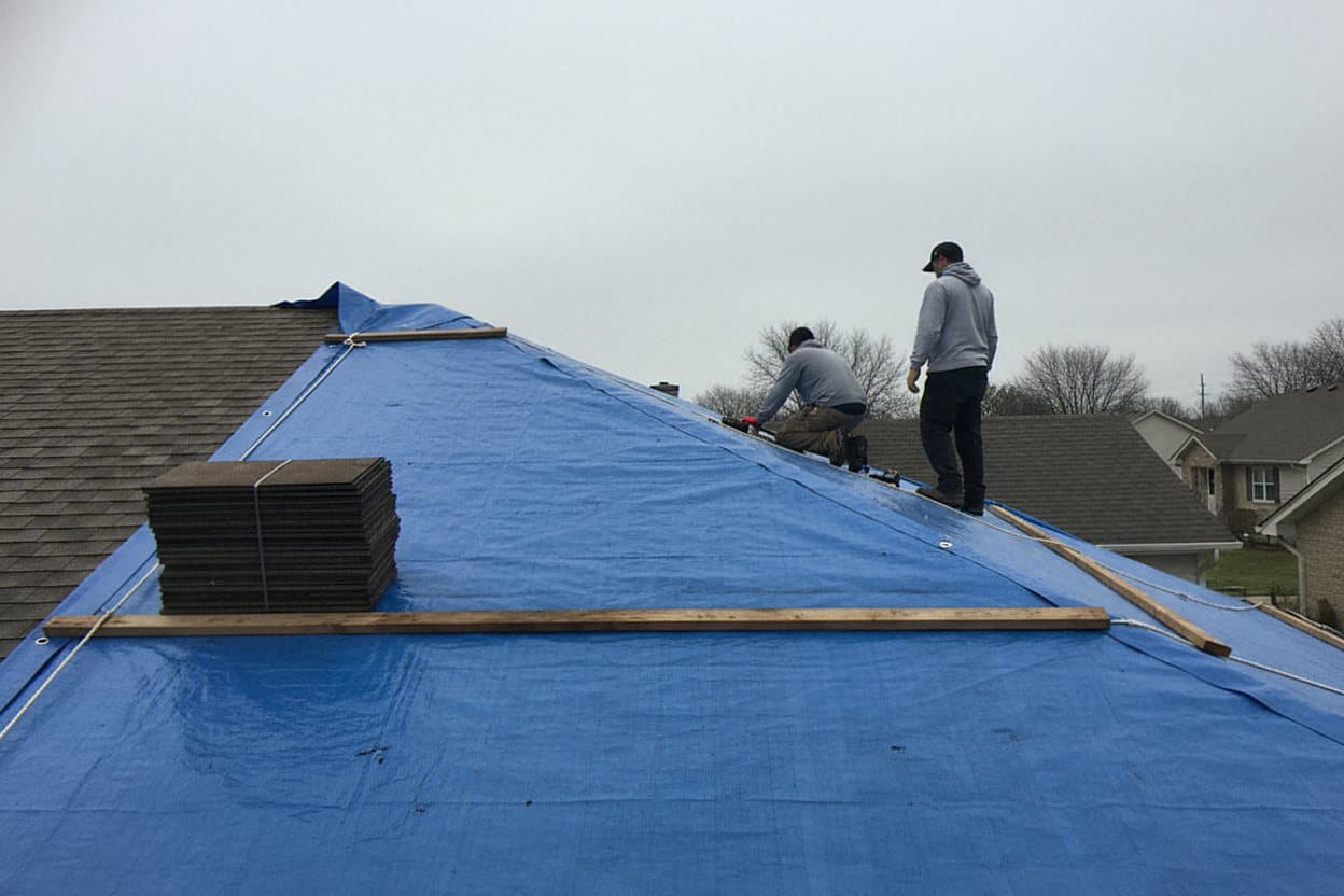 Emergency tarp over a storm damaged Dearborn home roof
